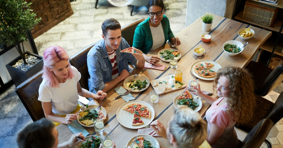 Overhead view of multiple friends eating together at a restaurant