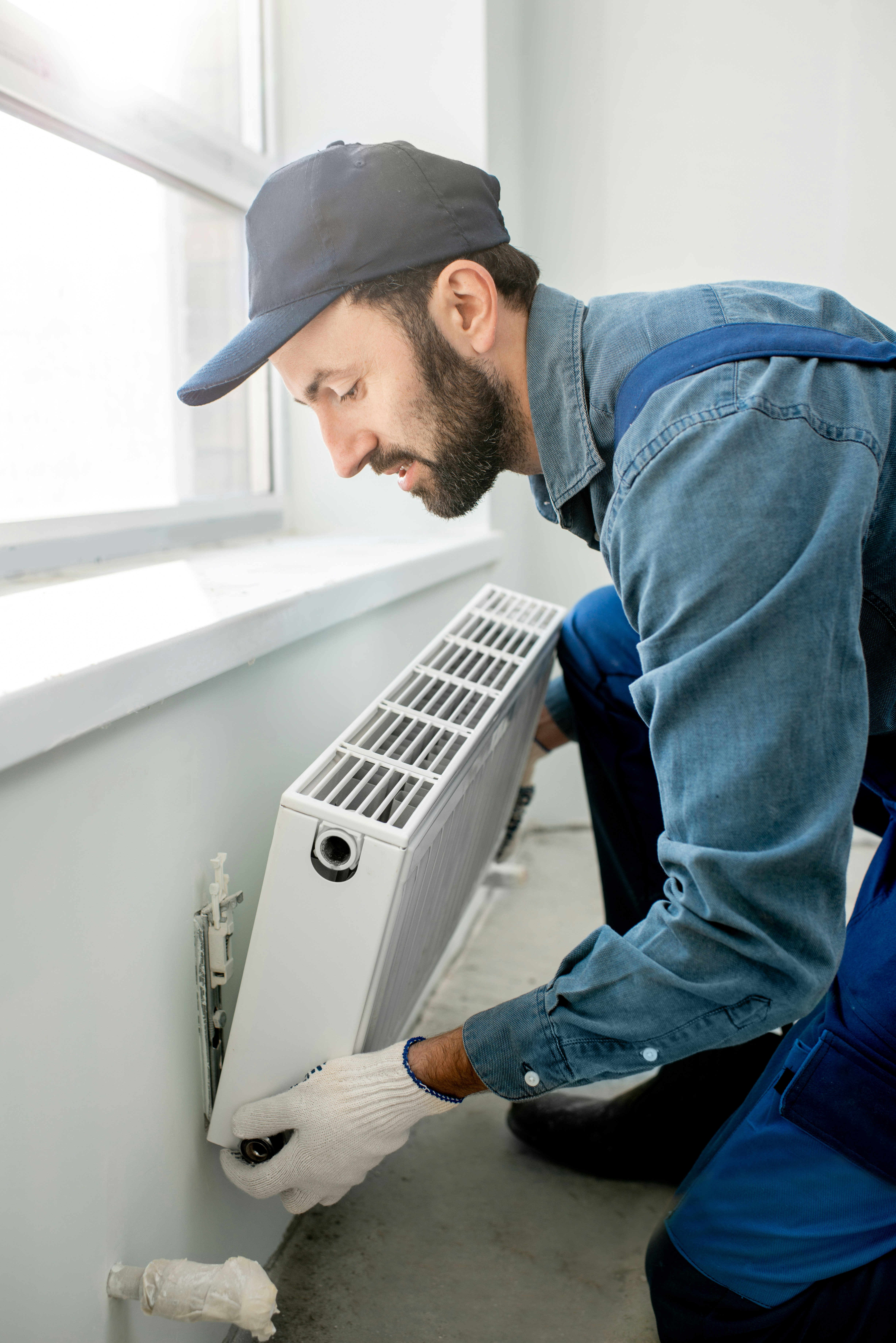 HVAC air technician inspects a unit after removing it from the wall