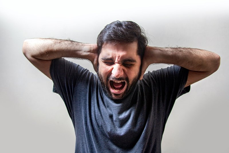 An upset tenant screams while covering his ears.