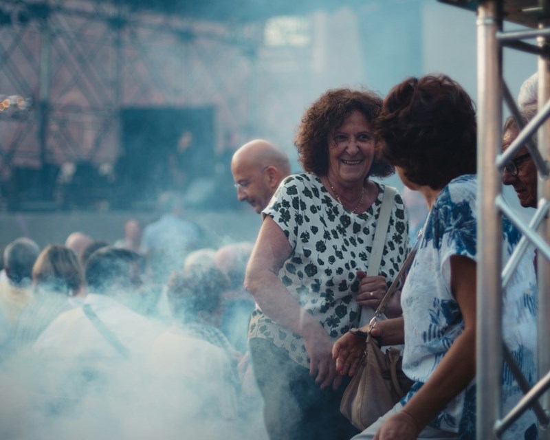 A group of people stand at a concert outside