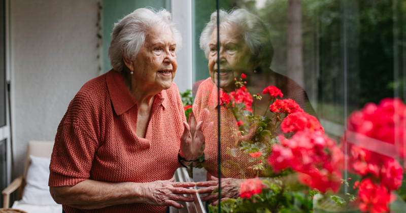 Cute old woman looking out her window. 