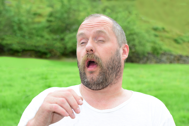 Middle-aged man sneezing.