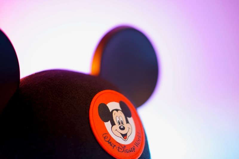 A black and orange mickey mouse cap illuminated by lights
