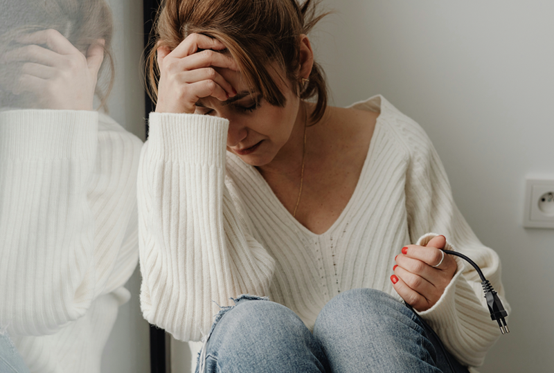 A woman holds her head in despair after being let go.
