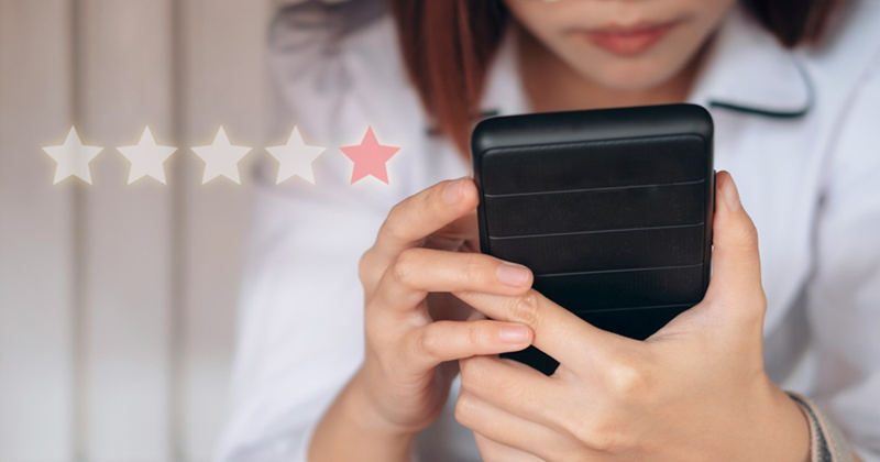A woman using her phone to leave a one star review