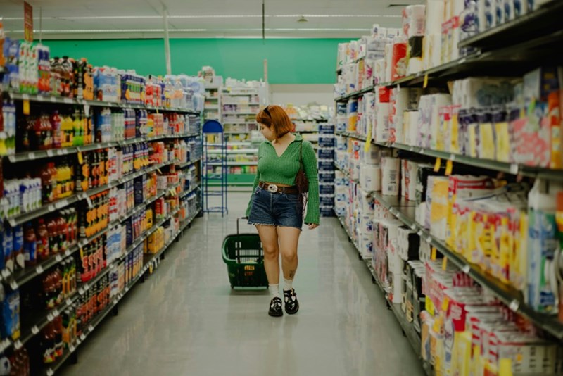 Woman shops for groceries in a brightly lit supermarket
