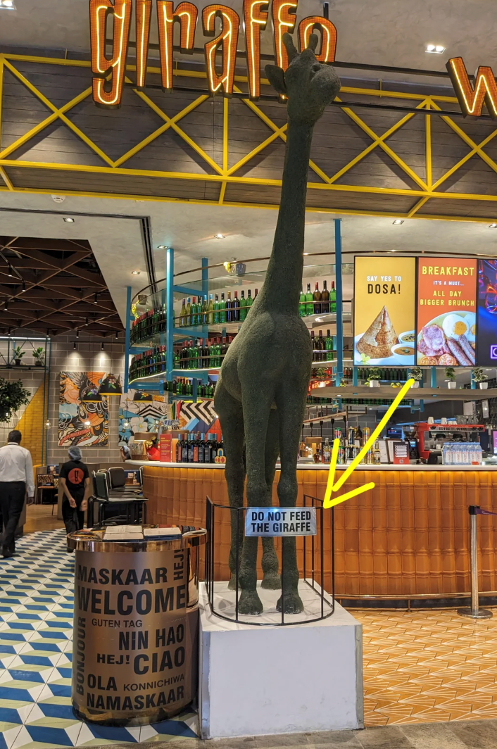 giraffo W MASKAAR WELCOME GUTEN TAG NIN HAO CIAO HEJ! OLA KONNICHIWA NAMASKAAR DO NOT FEED THE GIRAFFE SAY YES TO DOSA! BREAKFAST IT'S A MUST... ALL DAY BIGGER BRUNCH C