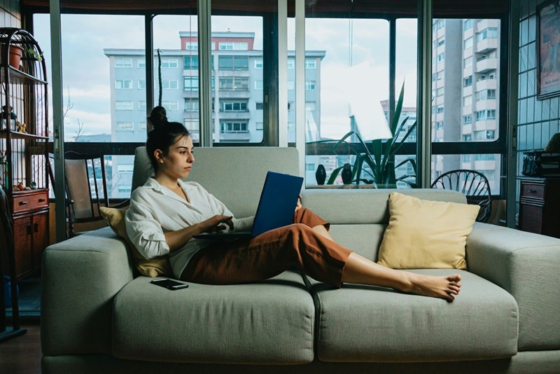 Woman in white long sleeve shirt sitting on white couch