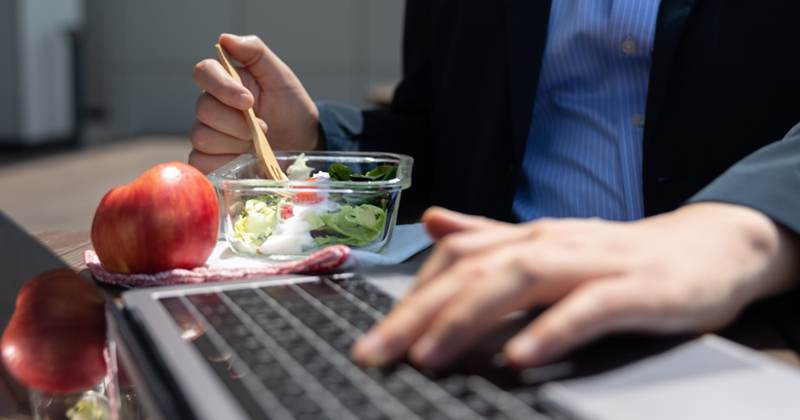 Guy taking his lunch break at his desk.