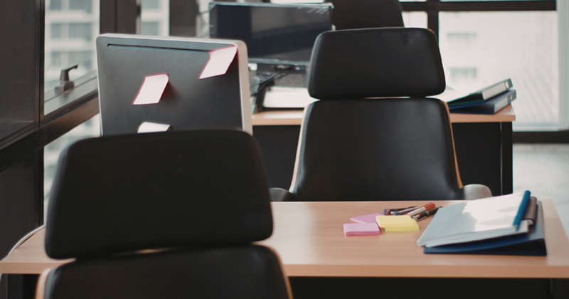 Empty office desks with chairs and office supplies