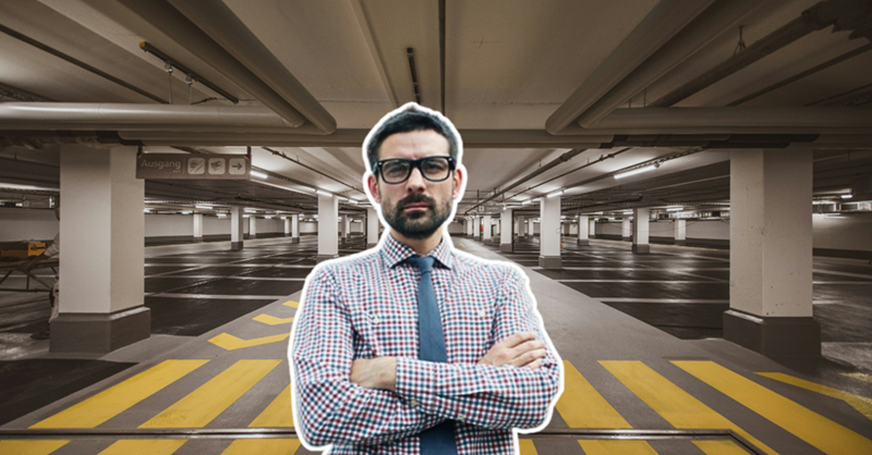A man stands with his arms crossed, pasted over an image of an empty parking garage lot.