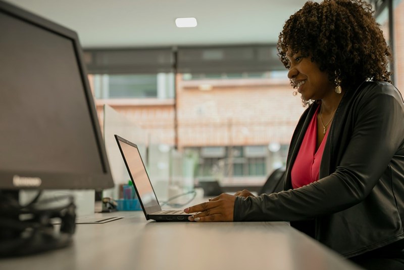 A woman sitting at a desk using a laptop computer