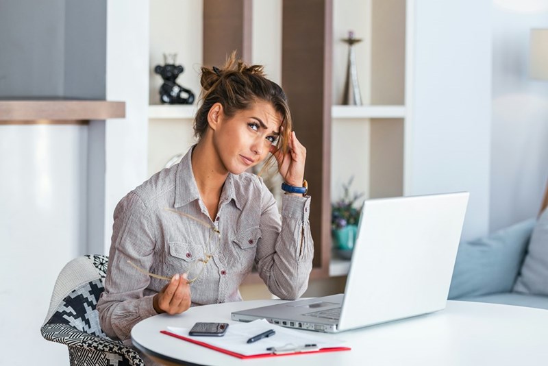 Woman looks away from work laptop in annoyance.