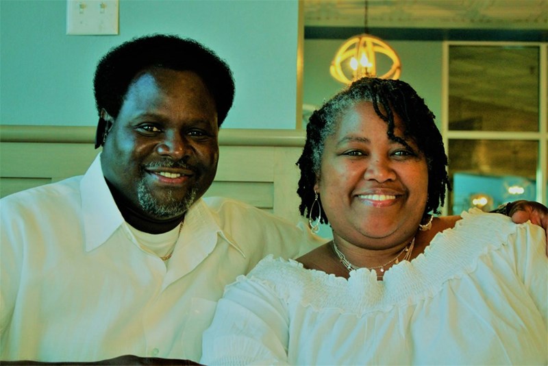 Man in white dress shirt smiling beside woman in white dress