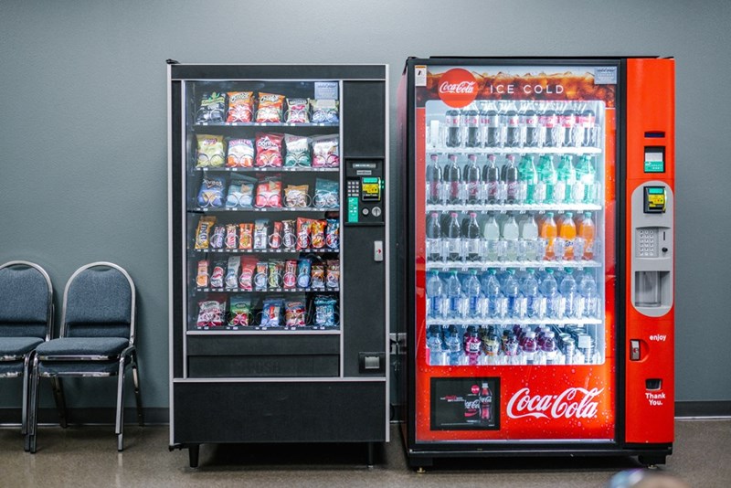 Two vending machines filled with snacks and sodas