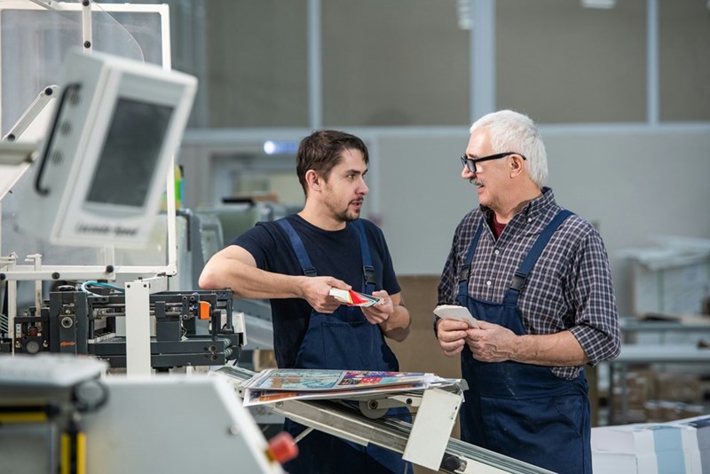 Employee and client talk about color choices while holding paint swatches.