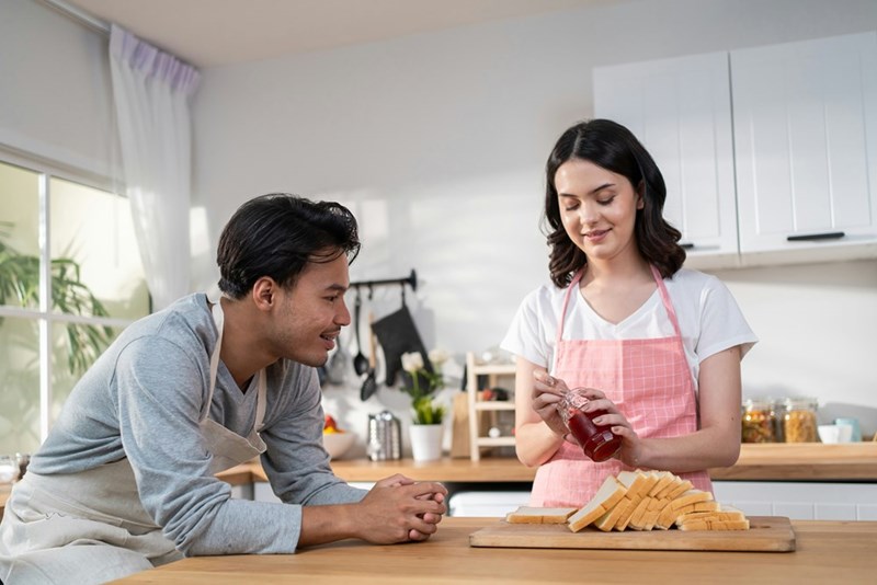 A couple cooks together in a kitchen