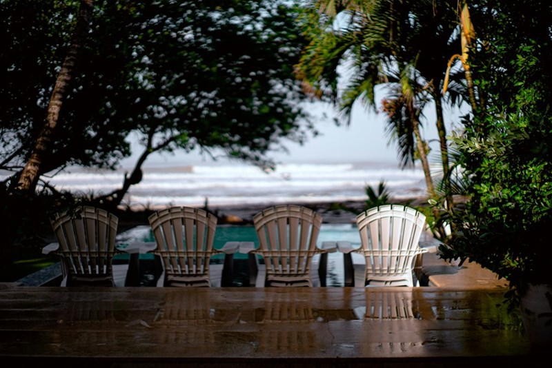A row of chairs set up on the beach at sunrise for a destination wedding