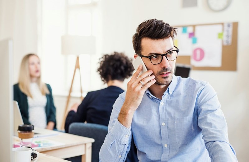 A male manager uses his cellphone in the middle of a meeting.