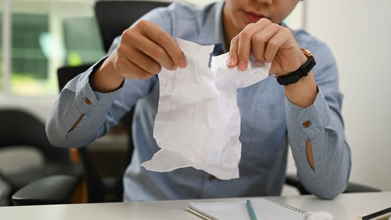 Well-dressed man ripping up a piece of paper