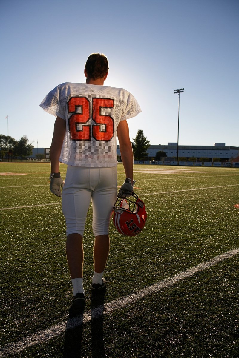 A football player is walking on the field