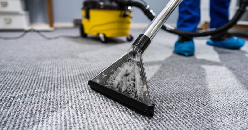 Person Cleaning Carpet With Vacuum Cleaner