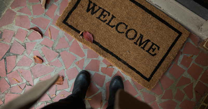 Person standing in front of their doormat.