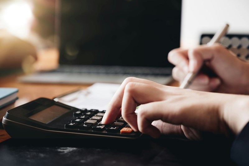 A set of hands calculating on a calculator.