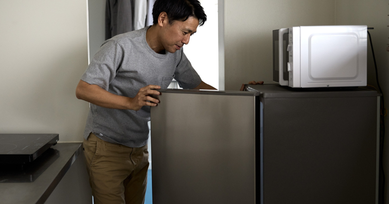 Man checking the fridge for his lunch at work. 