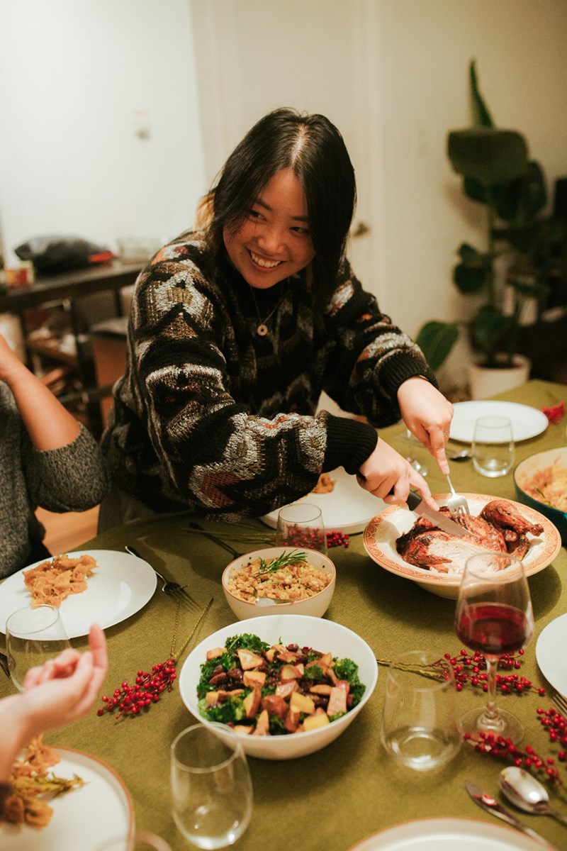 A woman sitting at a table with plates of food