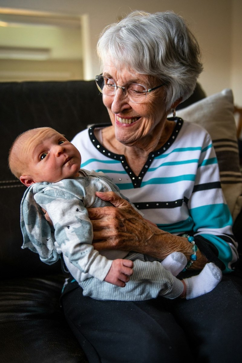 Grandma holds her newborn grandbaby, happy