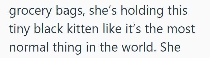 grocery bags, she's holding this tiny black kitten like it's the most normal thing in the world. She