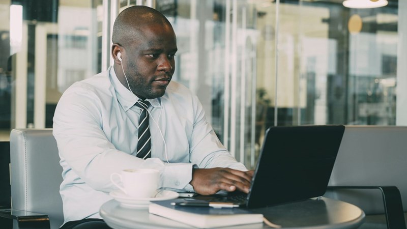 Man wearing headphones working on laptop