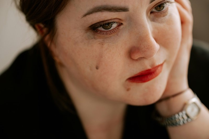 A woman sheds a tear looking sorrowful