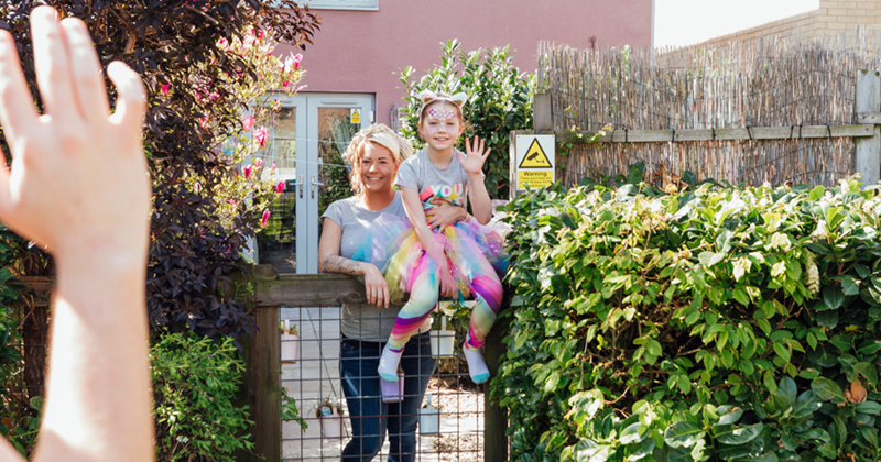 Woman waiving at the new neighbors on move in day.