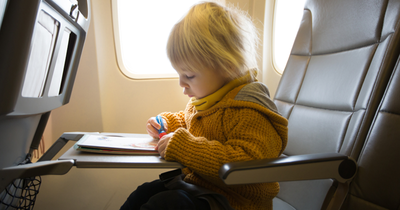 Toddler quietly playing during a flight at their seat. 