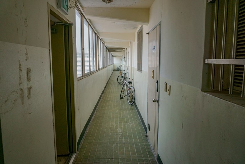 Apartment building hallway with white bicycle leaning on the wall