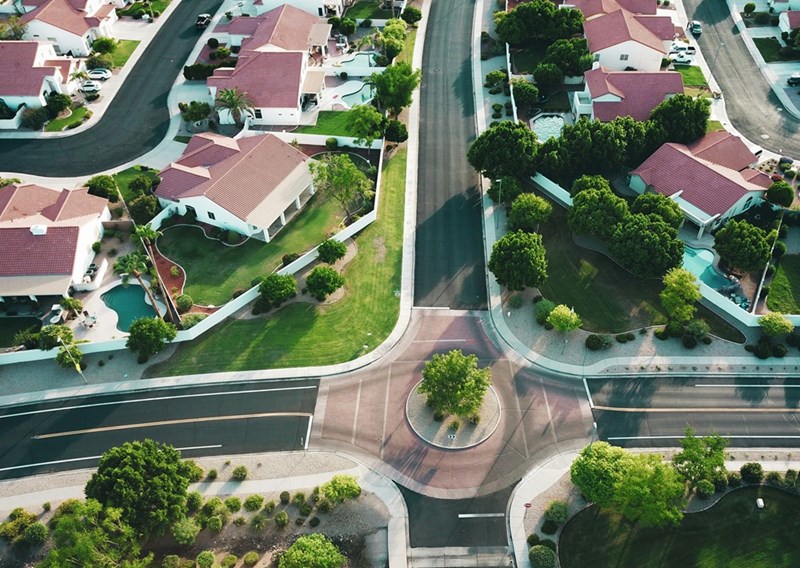 A series of identical white and red houses in an HOA neighborhood.