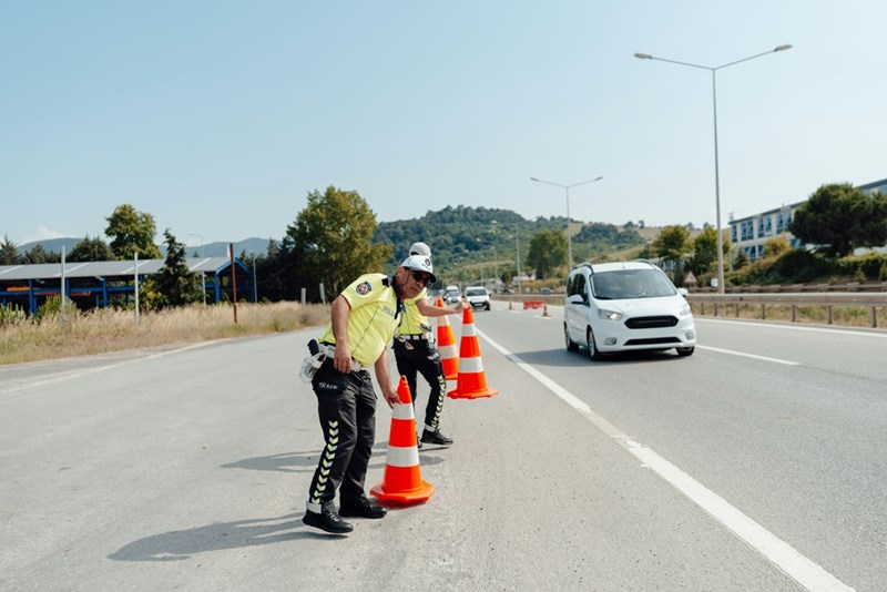 Traffic officers place orange cones on a public road that the HOA is funding.