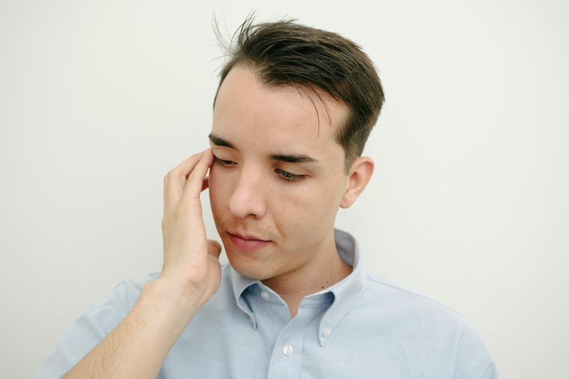 A close-up of the employee wiping away his tears.
