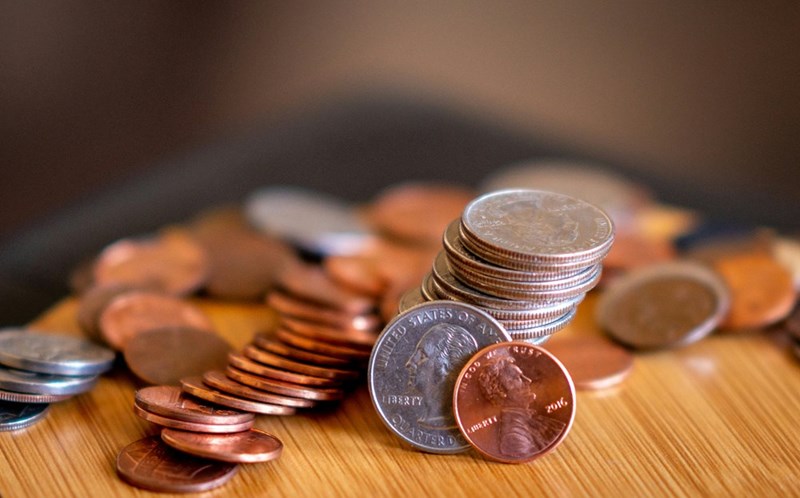 Quarters and pennies in a stack on a brown table
