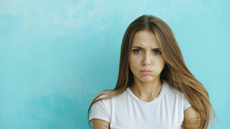 Woman looks displeased as she thinks about quitting her job.