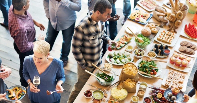 Overhead shot of party guests mingling in front of a buffet table