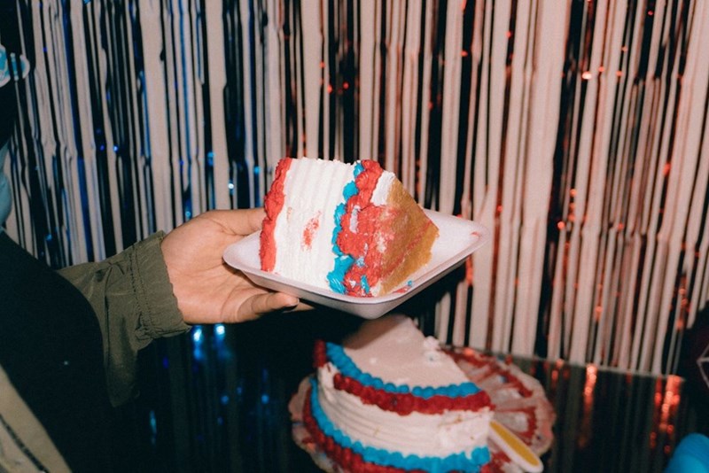 A man holding a piece of red, white, and blue cake
