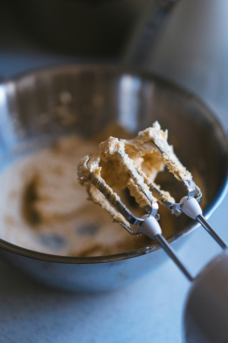A metal bowl filled with batter and a whisk