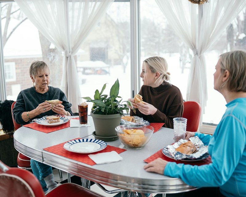 A group of people sitting around a table eating food