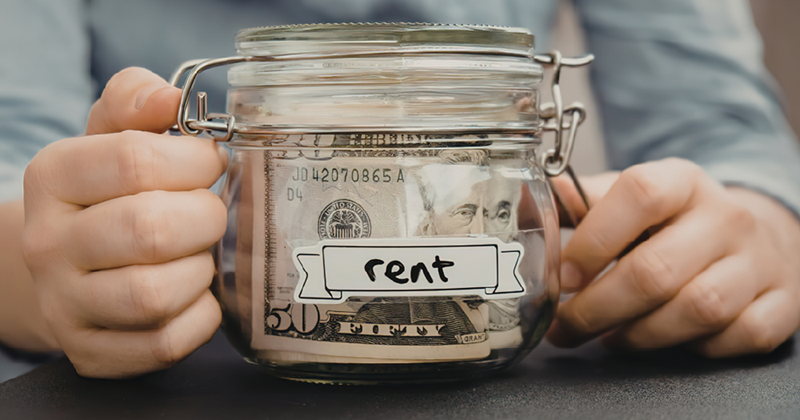 Person holding jar labeled with rent