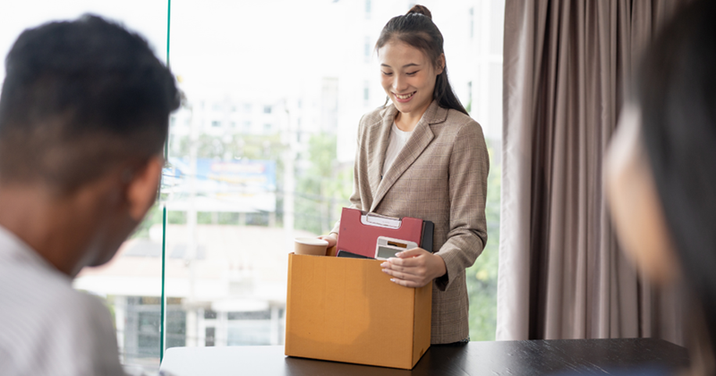 Female employee packing up her belongings and leaving office.