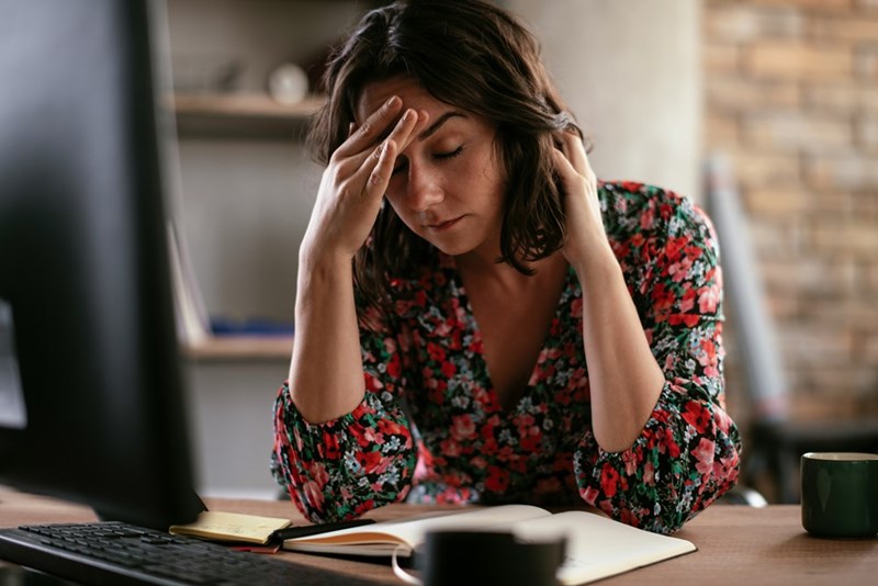 A frustrated businesswoman sits at her desk