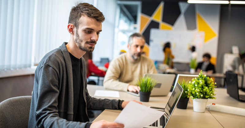Young man working in his open space workplace